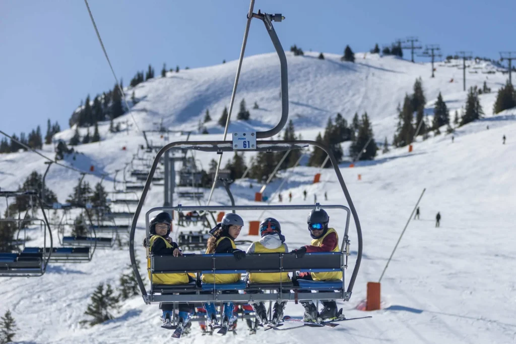 Jeunes sur un télésiège en camp d'hiver